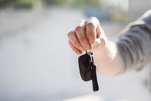 homme tenant une clé de voiture